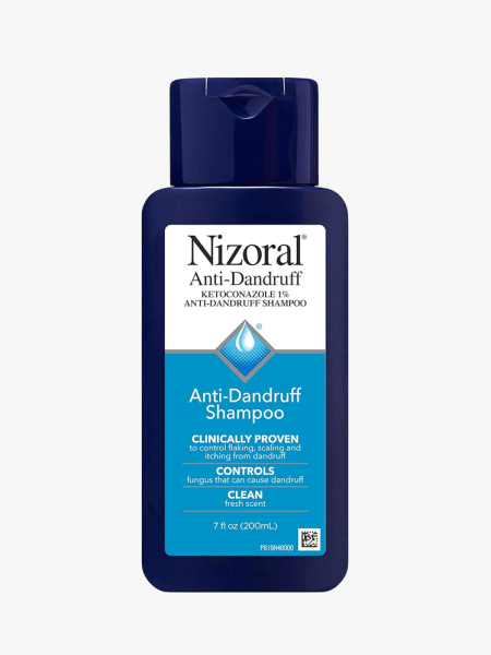 Nizoral Anti-Dandruff shampoo in navy blue bottle on a grey background
